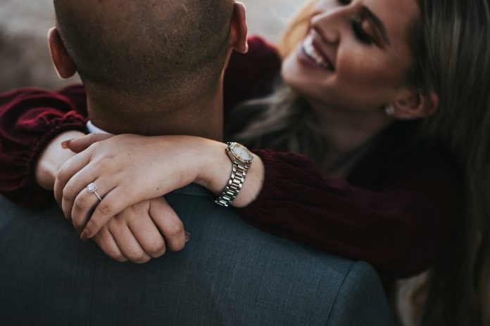 Photo by Nathan Dumlao man in black suit jacket kissing woman in red shirt