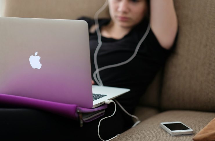 Stop Scrolling: How to Curate Your Adult Content Feed woman sitting on sofa with MacBook Air